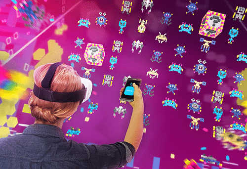 Eine Spielerin vor einem riesigen Bildschirm, der die Mixed-Reality-Installation "Galaxy Invaders VR" spielt, ein Spiel für Samsung, das vom Mixed-Reality-Spielestudio Gbanga entwickelt wurde. A player in front of a huge monitor screen, playing mixed-reality installation «Galaxy Invaders VR», a game for Samsung, created by mixed-reality game studio Gbanga.
